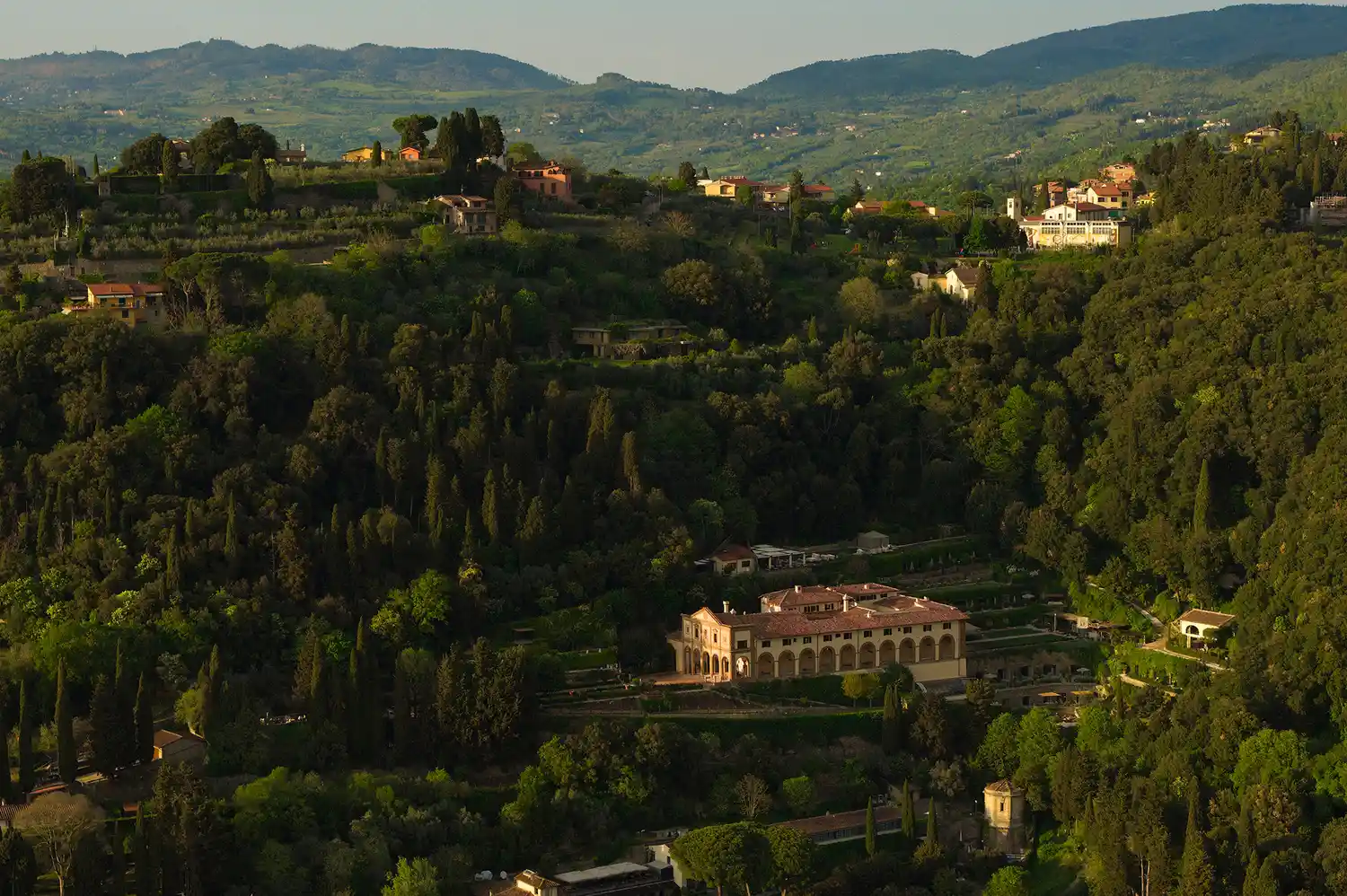 Aerial perspective of Villa San Michele nestled in the lush greenery of the Fiesole hills.