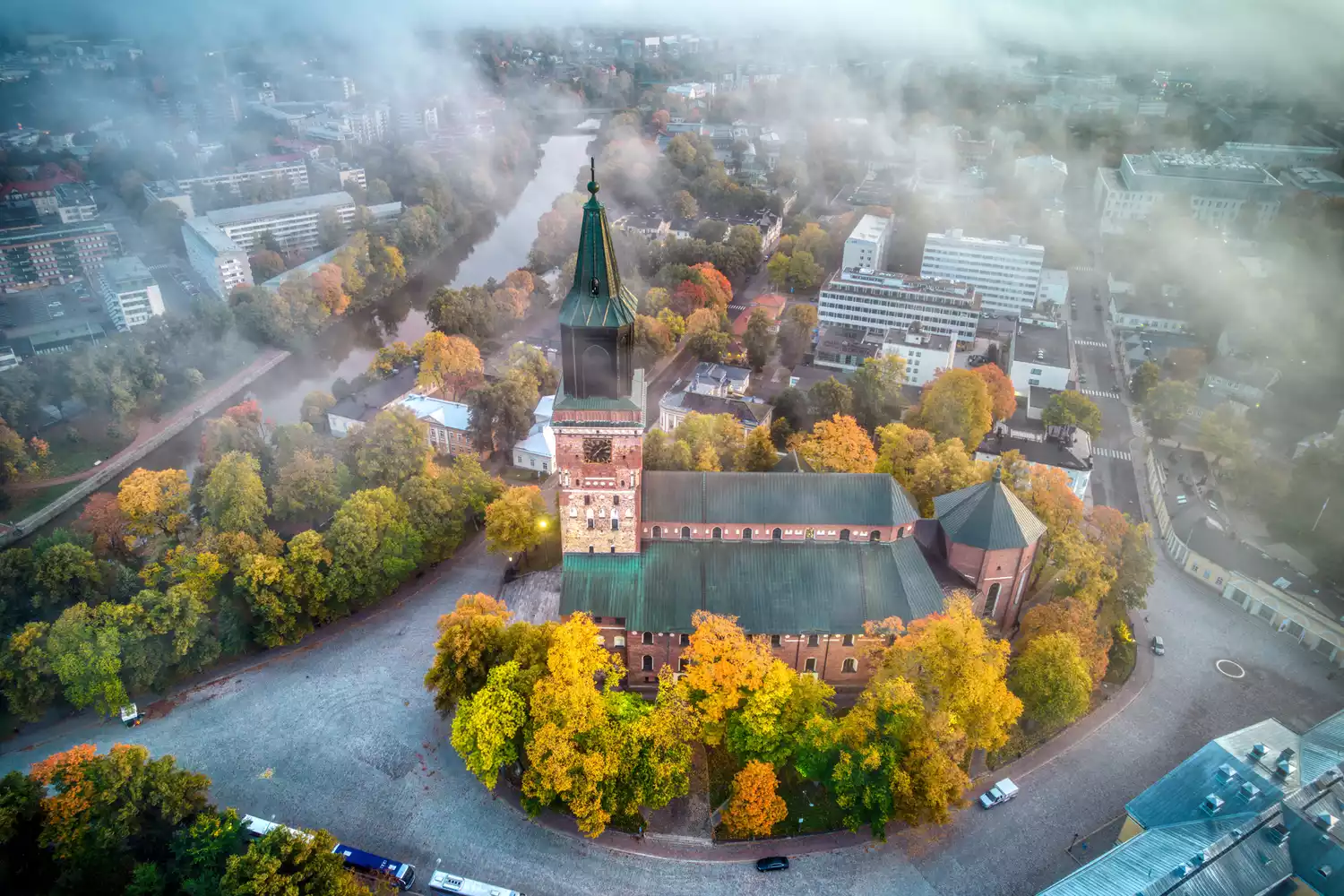 An aerial perspective of the historic Turku Cathedral surrounded by trees.