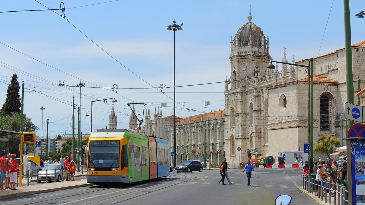 A classic yellow tram climbing a steep street in the historic Alfama district of Lisbon.