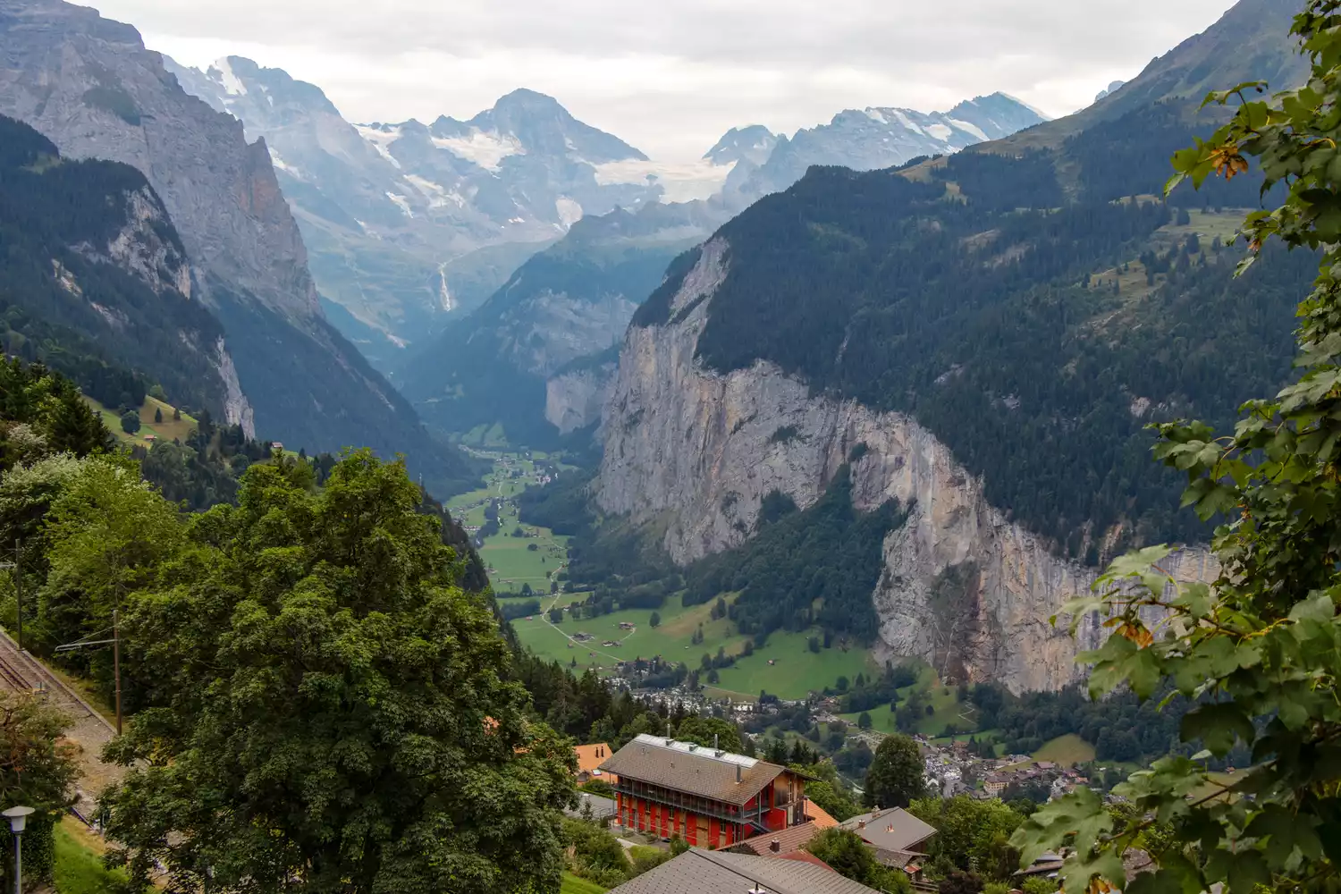 A deep mountain valley with steep cliffs and a small village in Lauterbrunnen, Switzerland.