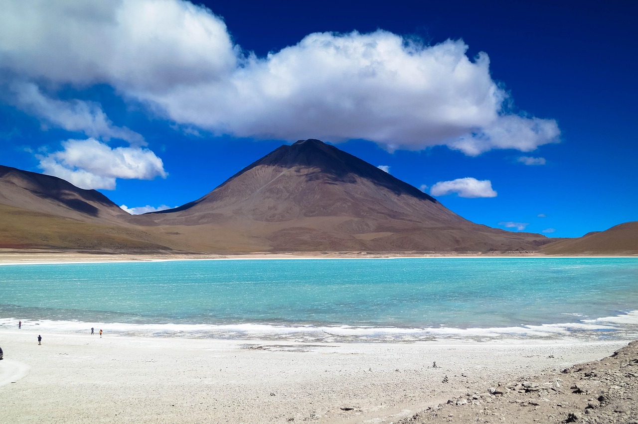 The barren, reddish landscape of the Andes with a volcanic peak in the background.
