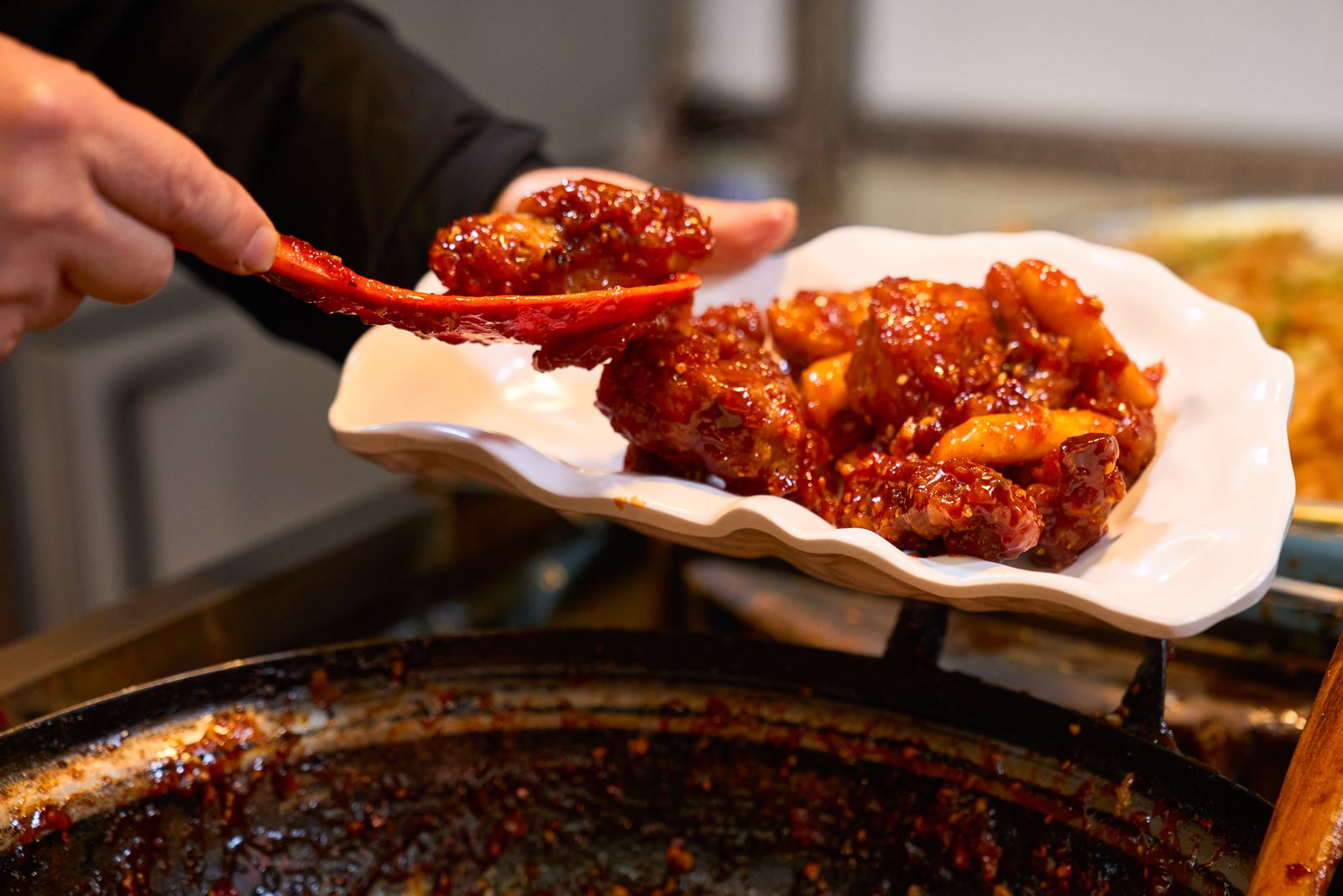 Extreme close-up of Yangnyeom glazed fried chicken with a glossy finish.