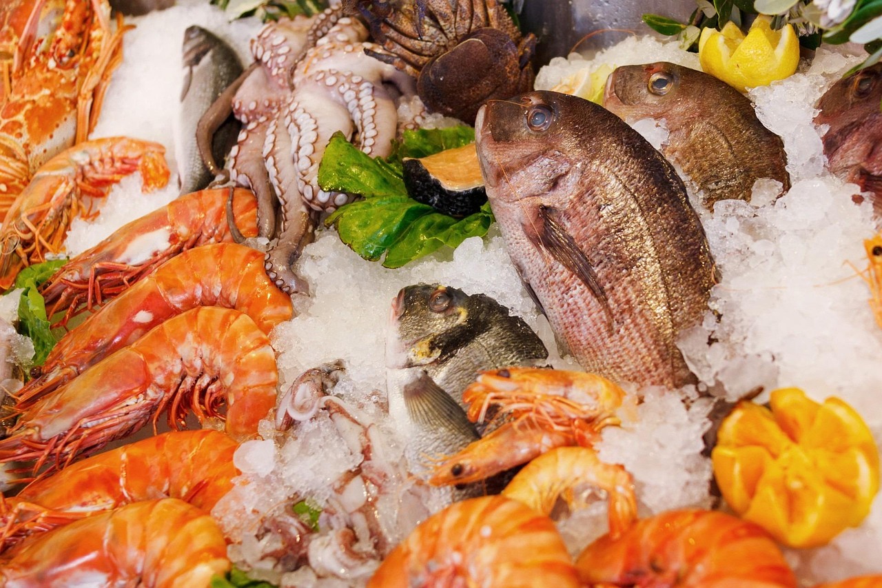 A fresh seafood platter featuring large cooked prawns on a restaurant table