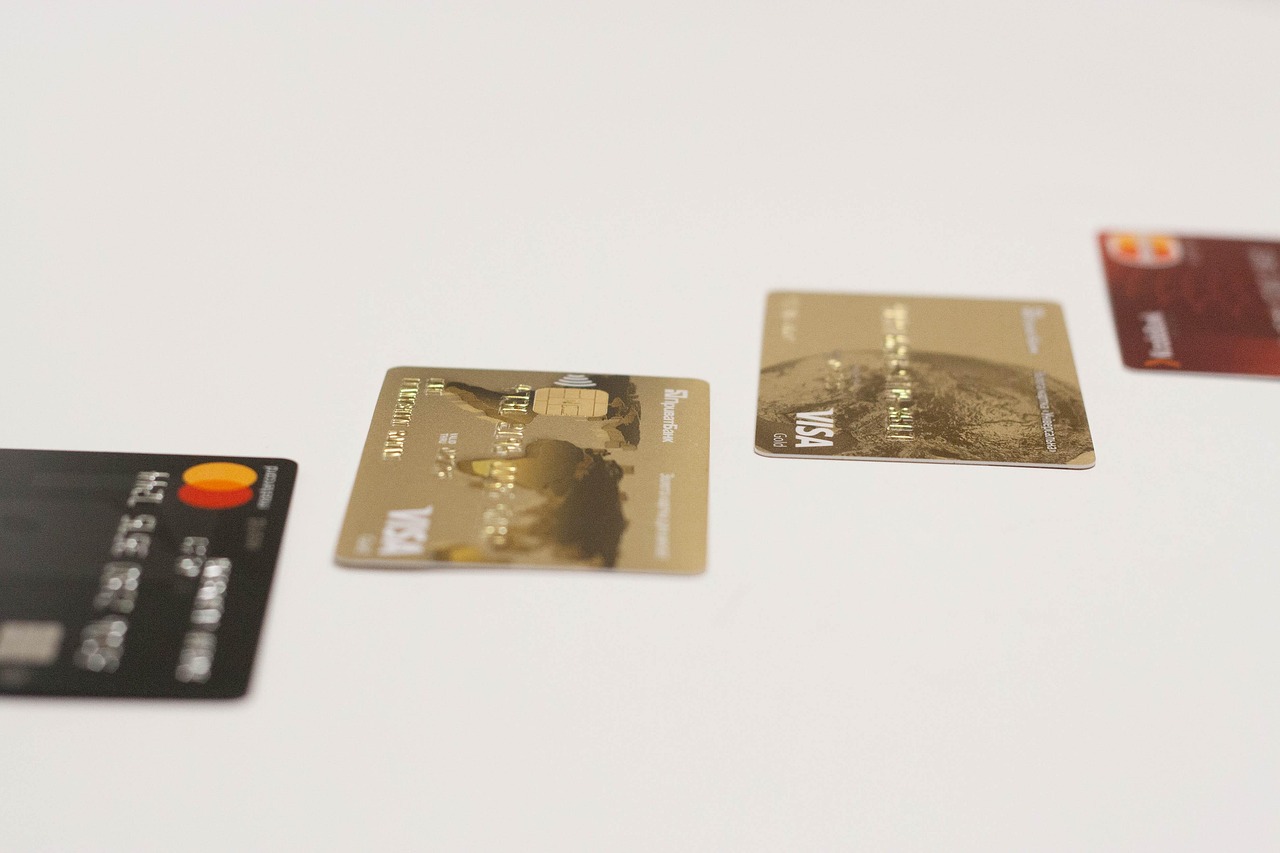 A person holding a premium metal credit card at an airport terminal gate