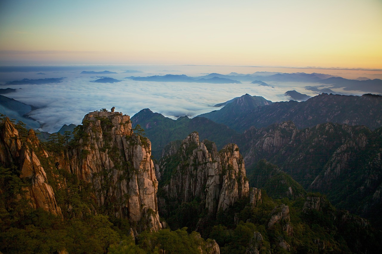 A panoramic view from a high mountain peak looking out toward the distant sea.