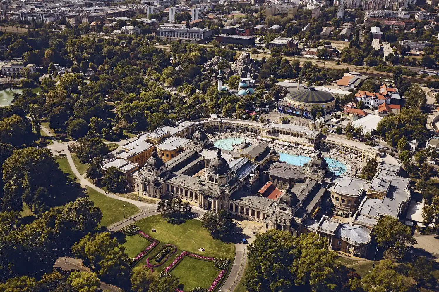 An aerial perspective of the yellow neo-Baroque buildings and outdoor pools of Széchenyi Thermal Bath.