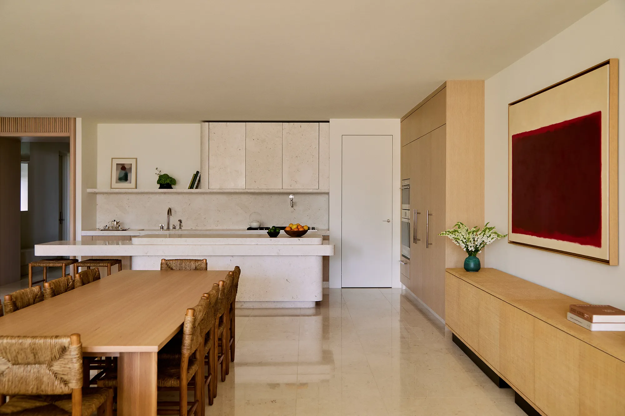 Minimalist kitchen and dining area featuring natural wood finishes and clean architectural lines.