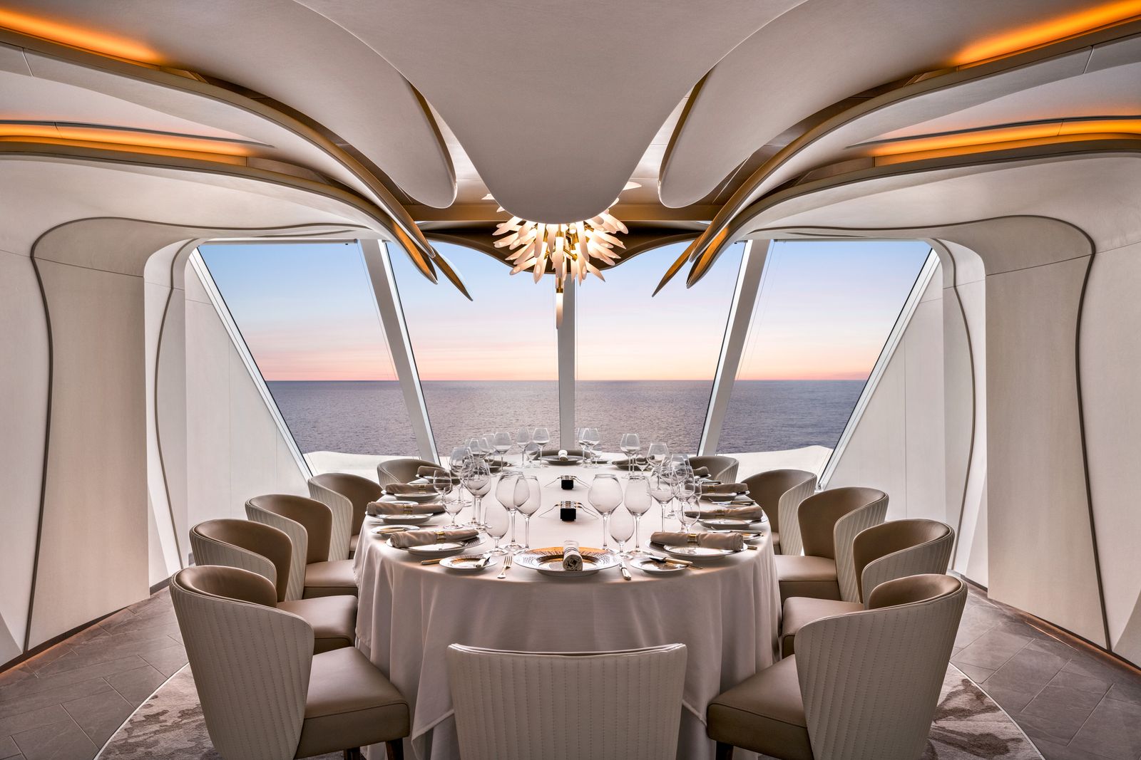 An elegant cruise ship dining room with communal tables and high-end cutlery.