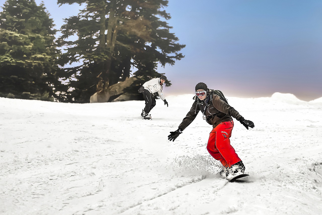A snowboarder catching air in a terrain park against a mountain backdrop.