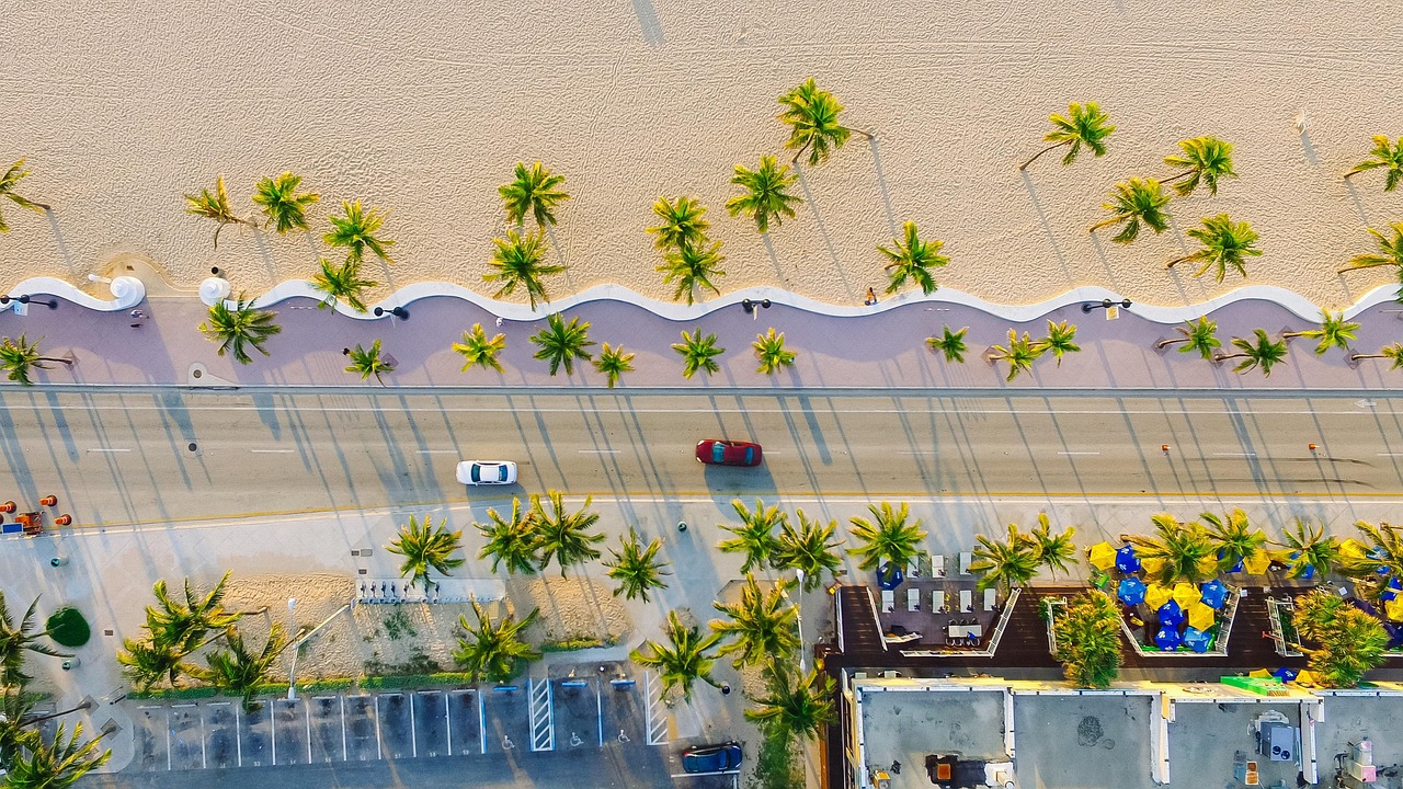 High altitude view of a wild crescent-shaped beach surrounded by green mountains.