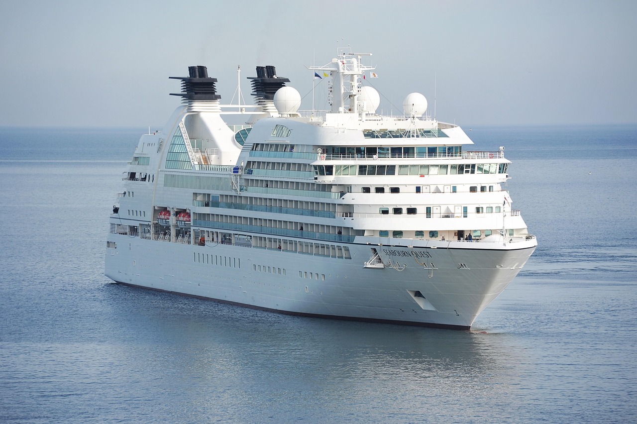 A luxury cruise ship upper deck featuring a swimming pool and comfortable lounge chairs.