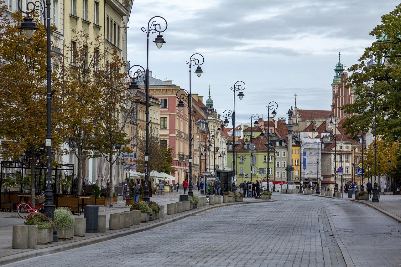 A traveler walking through a European city street with autumn leaves, wearing a stylish hybrid fleece.