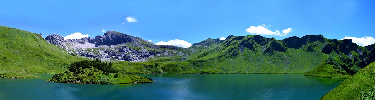 A tent pitched on a dry, elevated plateau overlooking a valley lake.