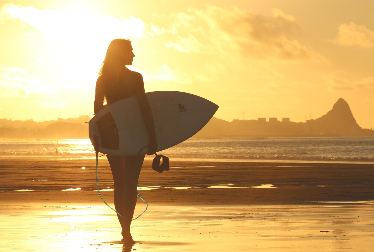 A group of surfers carrying their boards walking together along a beautiful coastline.