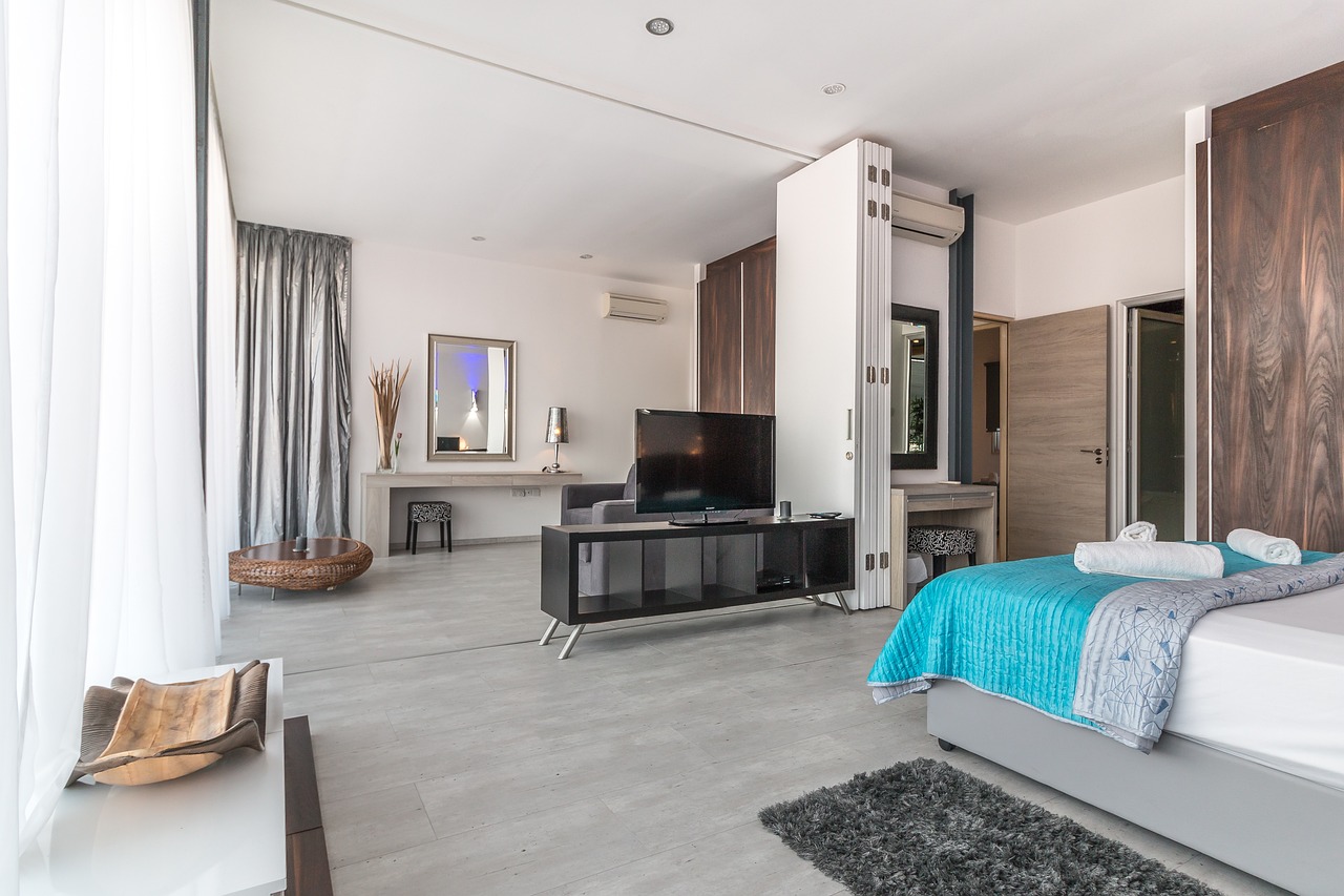 A clean, bright, and modern hotel suite with a large bed.