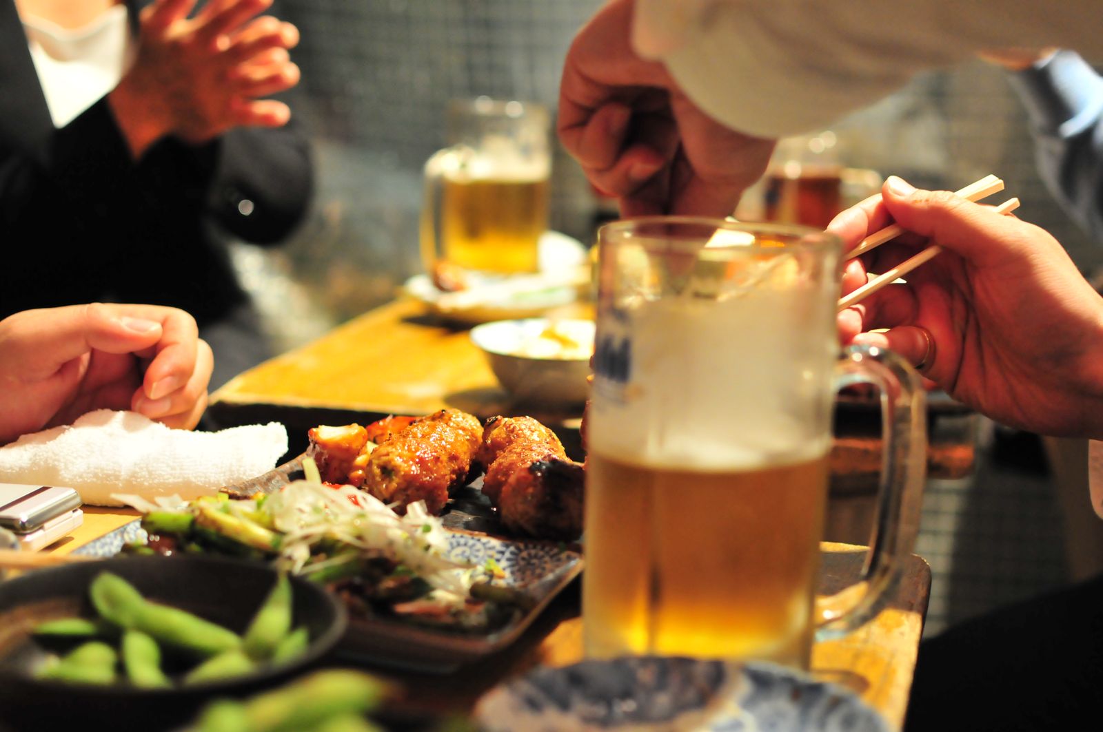 A restaurant table set with fried chicken, a glass of beer, and traditional side dishes.