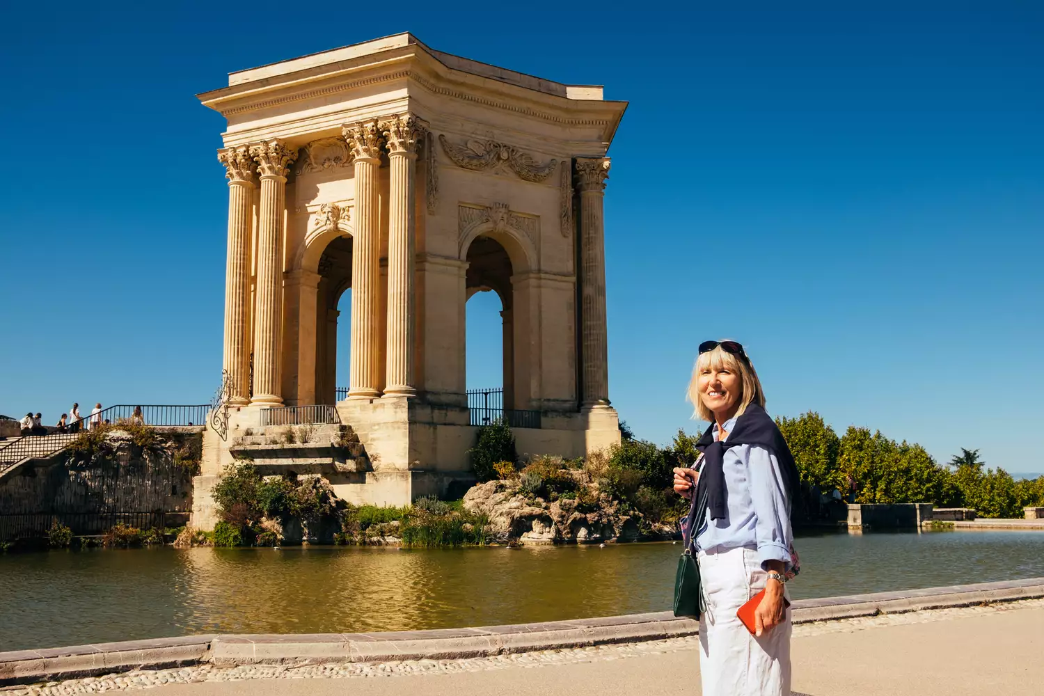 A woman tourist exploring the historical Promenade du Peyrou in Montpellier, France.