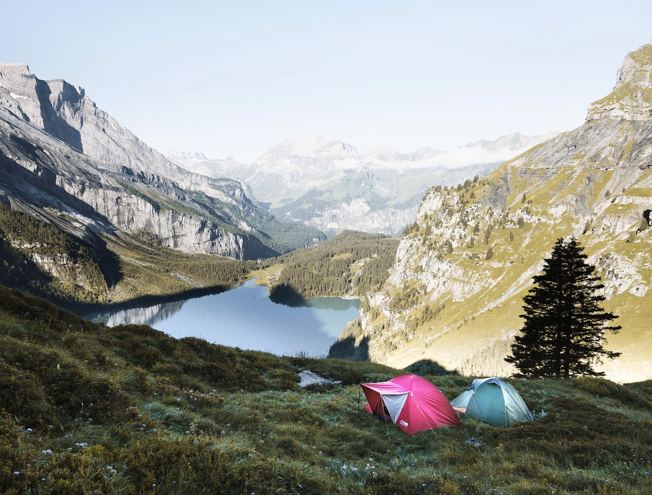 A professional dome tent set up next to a serene alpine lake.