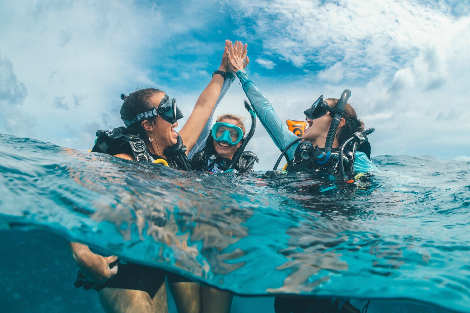Close-up portrait of a female diver wearing a scuba mask and regulator.
