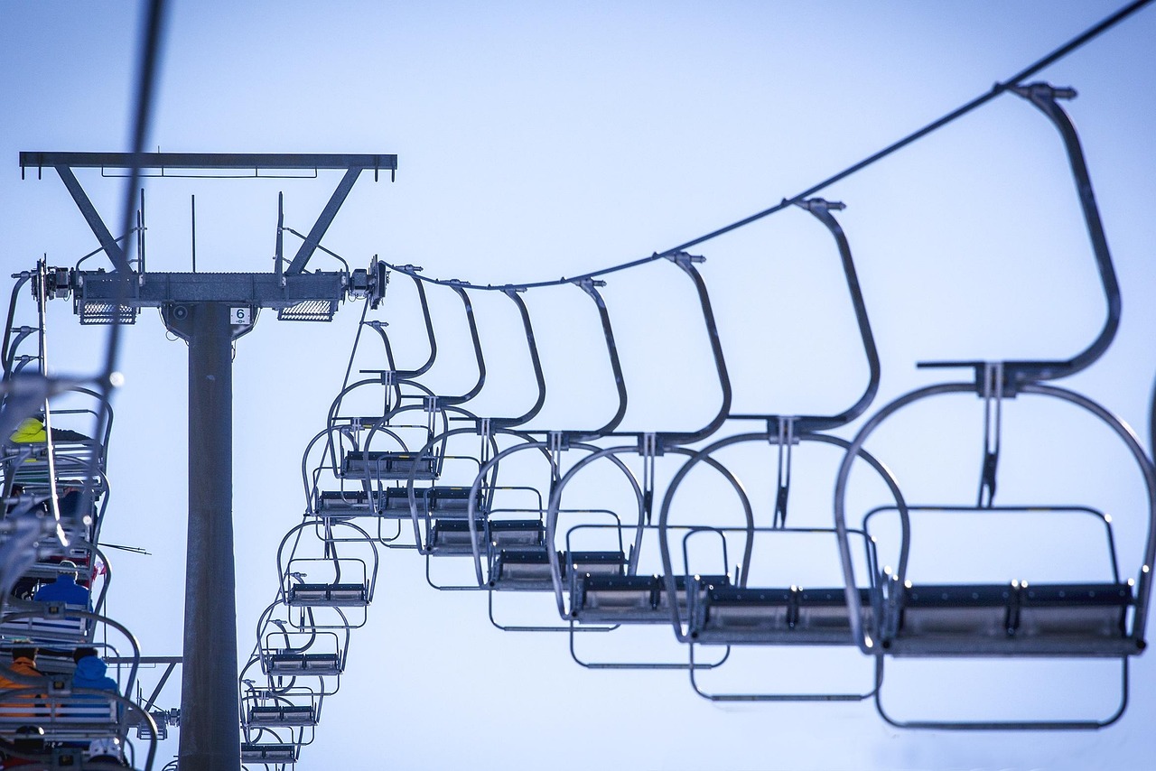 A ski lift ascending a massive snow-covered mountain at Mammoth Mountain resort.