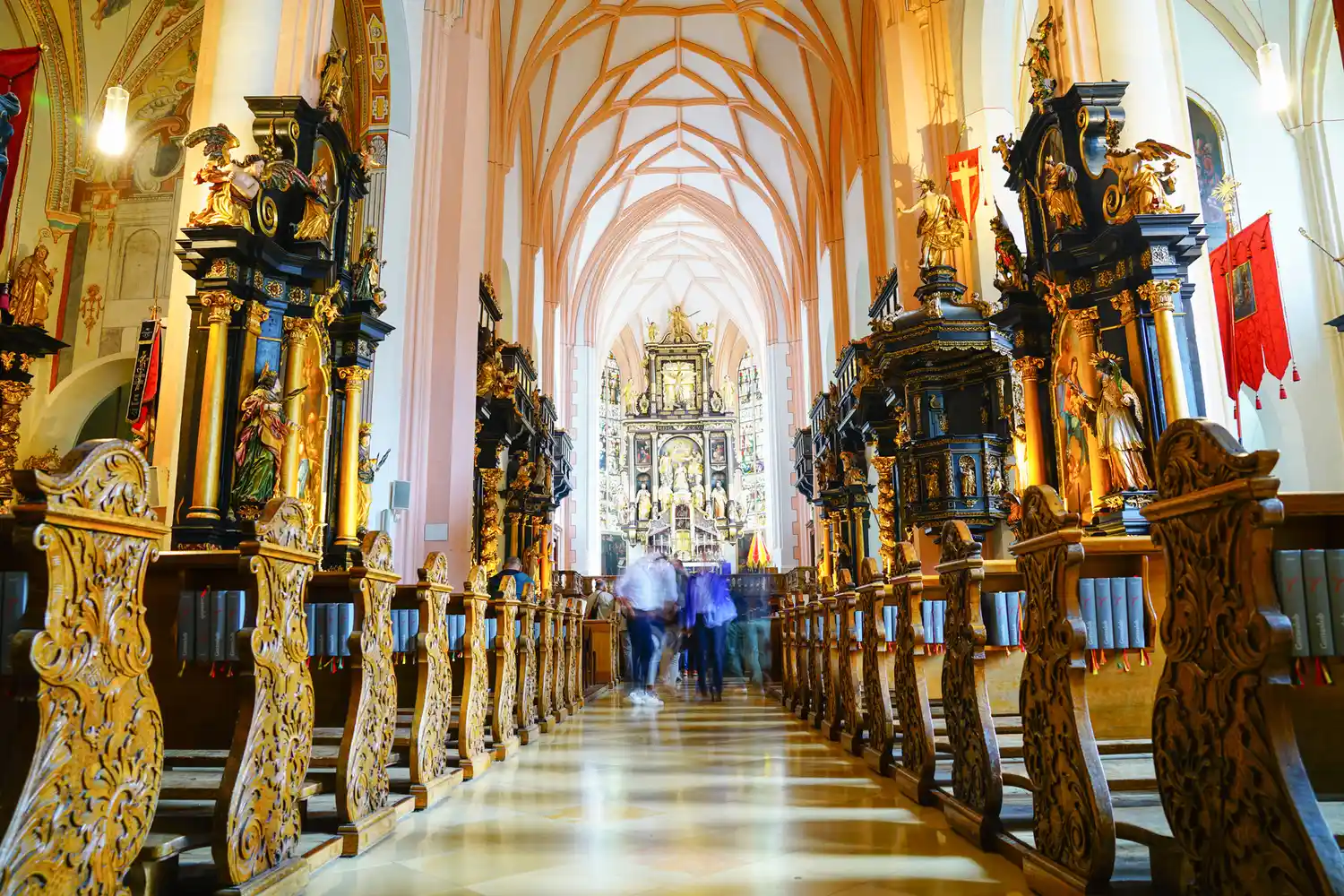 The interior of the Mondsee Basilica showing the altar and ornate architectural details.
