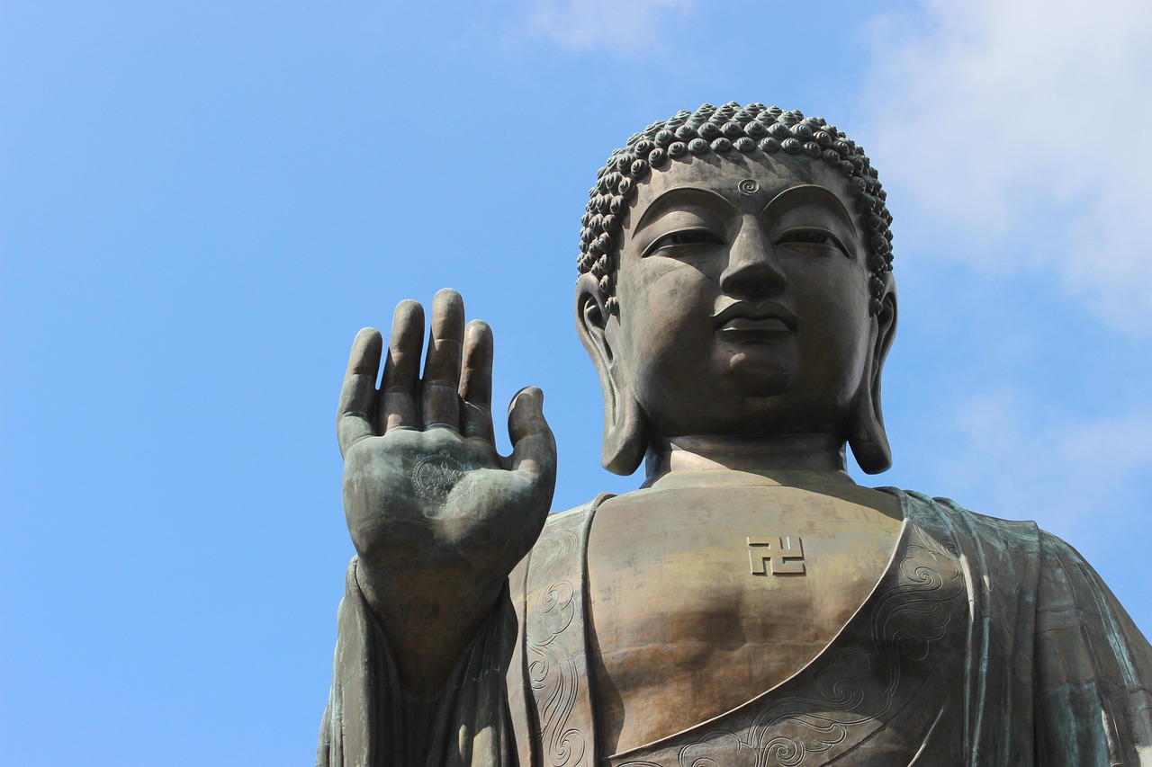 The massive bronze Tian Tan Buddha statue sitting atop Lantau Island under a clear blue sky