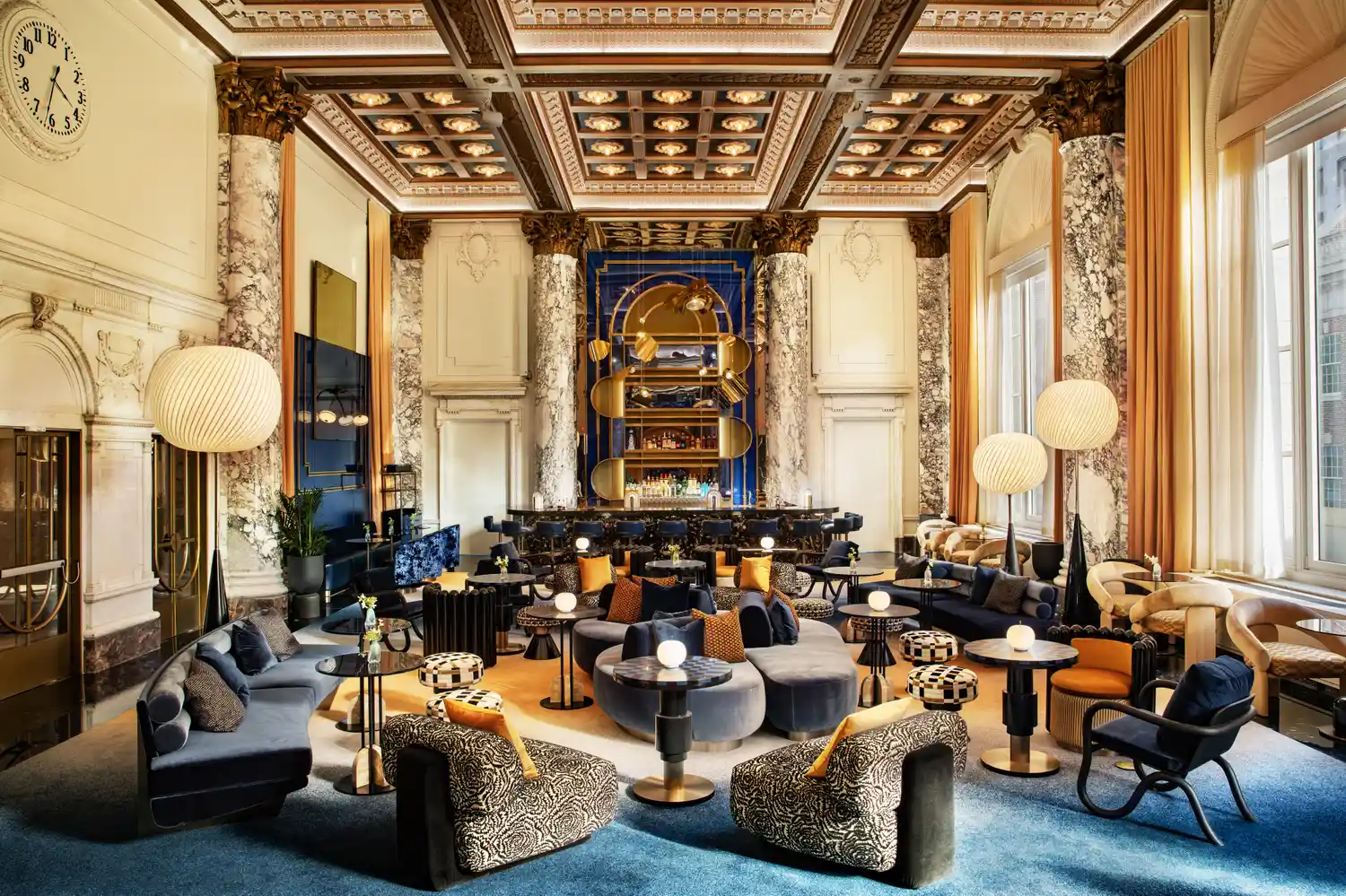 An expansive lounge area at W Union Square with high ceilings, ornate detailing, and contemporary seating.