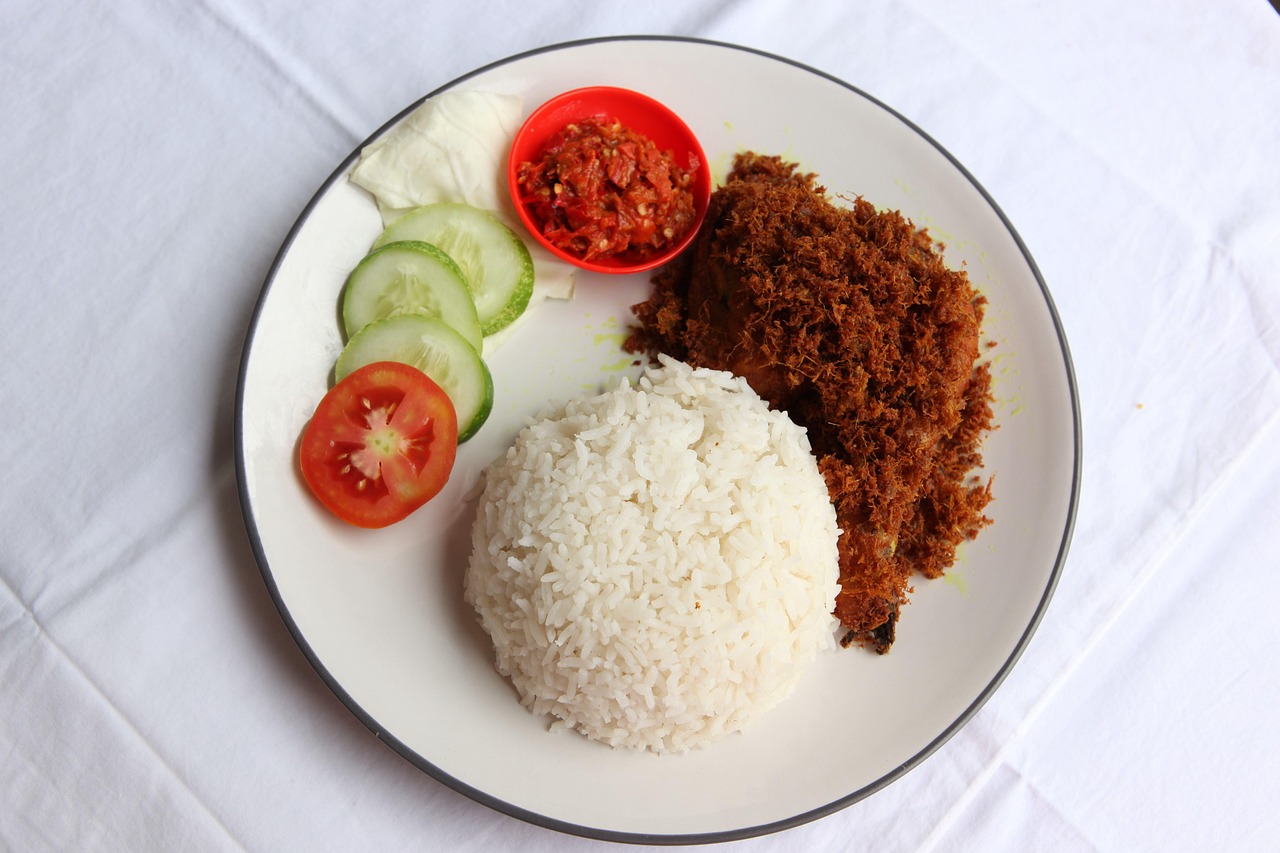 A plate of Balinese Nasi Campur with various meats, vegetables, and rice.