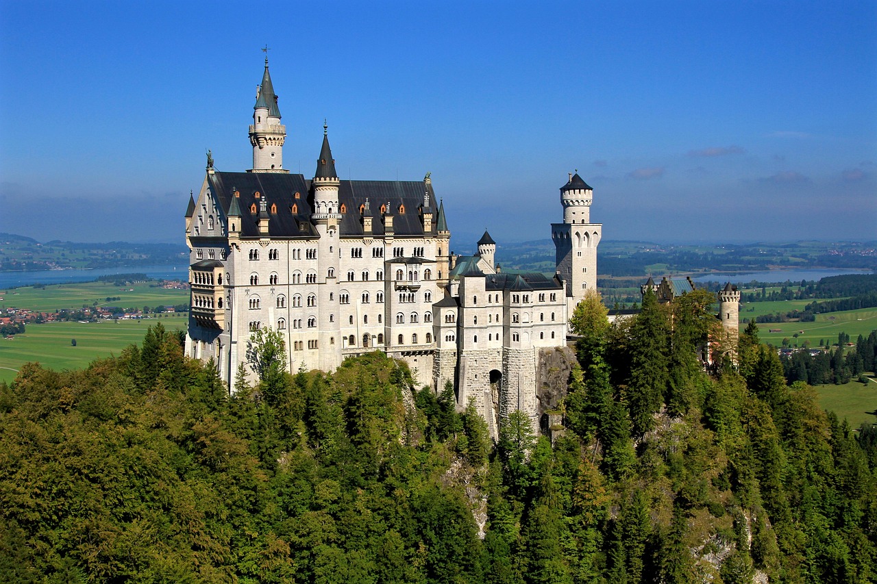 A majestic castle nestled in a lush green forest, resembling a fairy-tale setting.