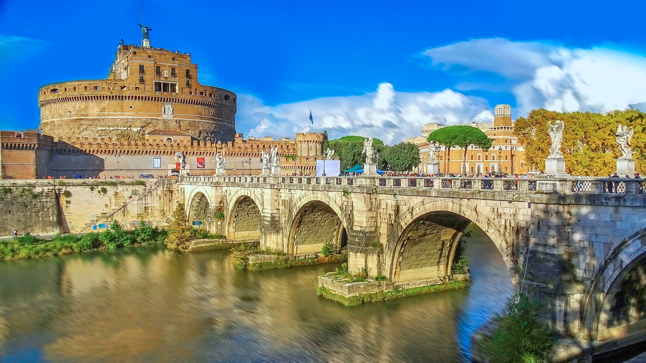 The Tiber River in Rome during autumn with golden trees and Castel Sant'Angelo in the background.