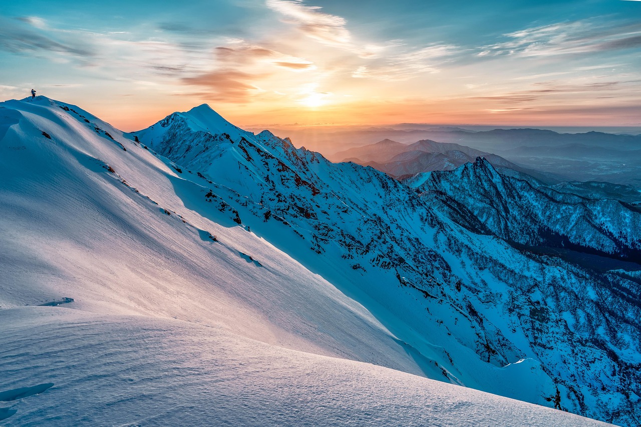 Panoramic view of snow-capped mountain peaks under a bright winter sun.