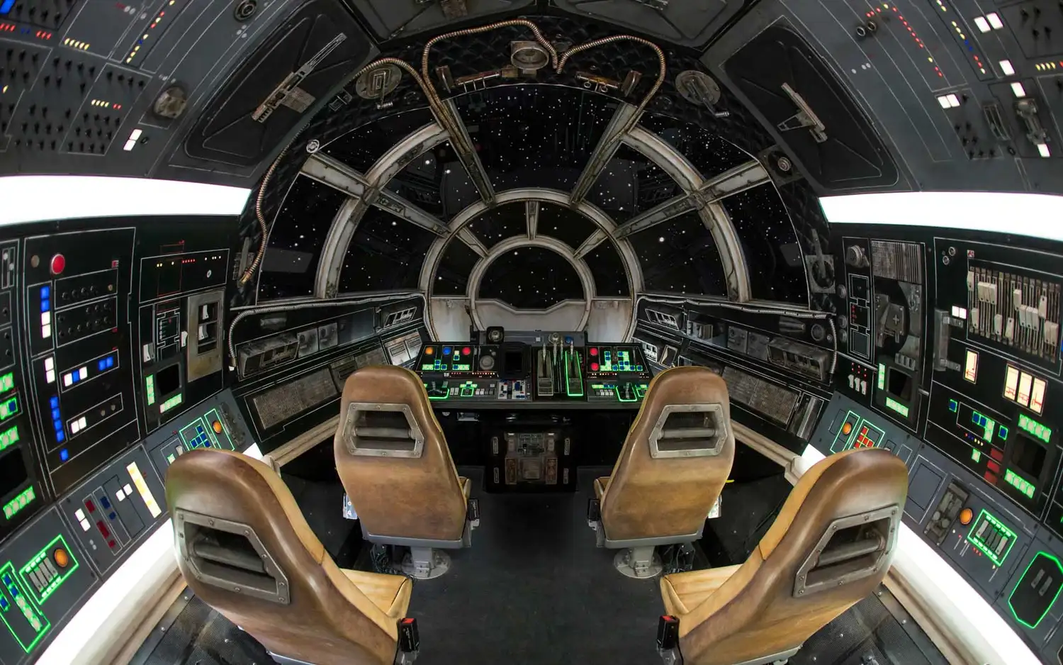 The interior cockpit of the Millennium Falcon with glowing buttons and flight controls.