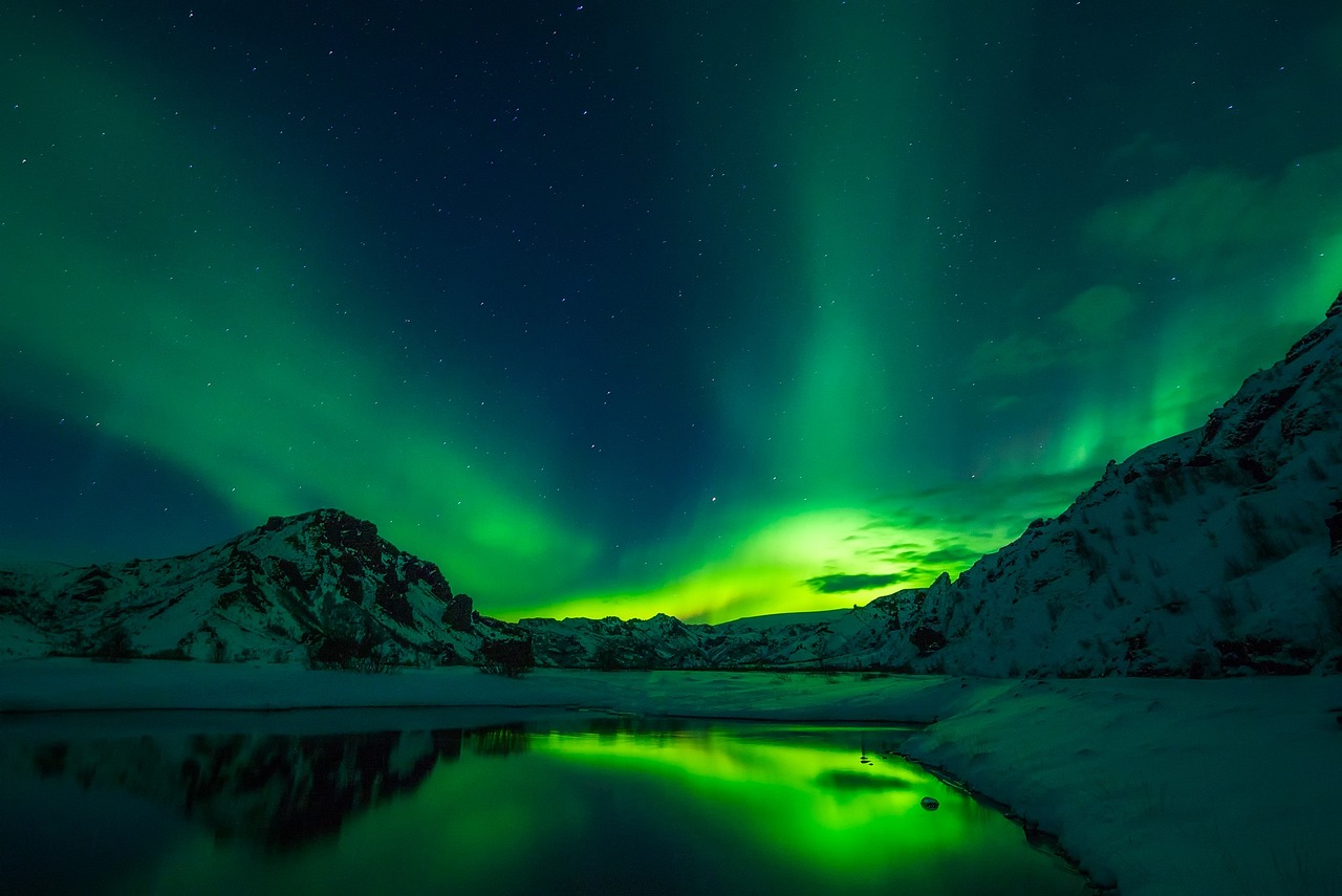 Green northern lights dancing over a snowy landscape