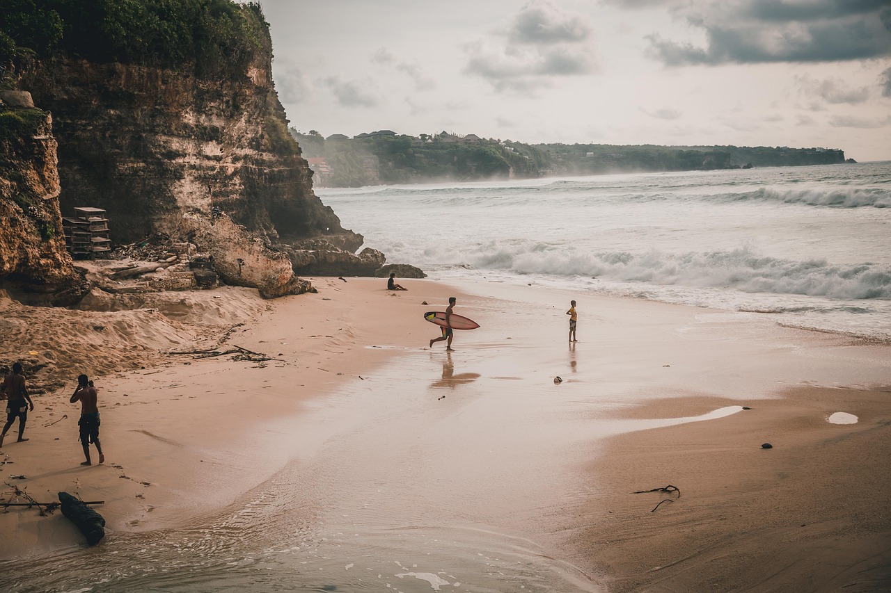 Uluwatu Temple perched on a steep cliff above the Indian Ocean at sunset.