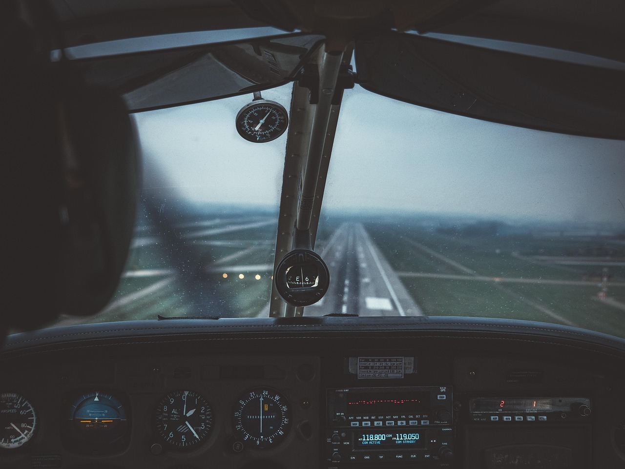 A small charter aircraft on a dusty desert landing strip.