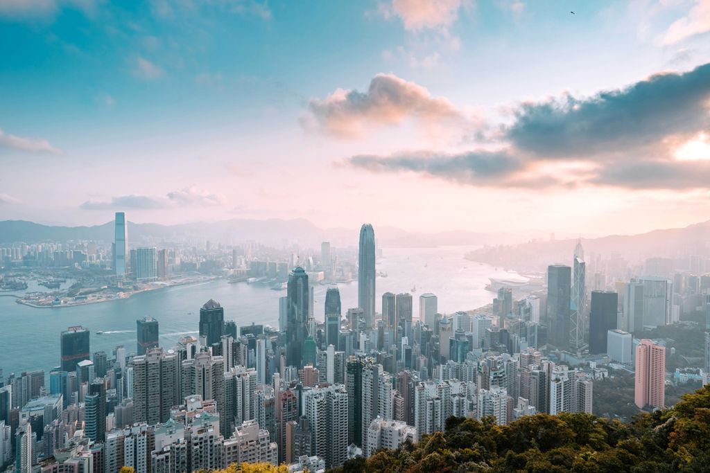 The Hong Kong skyline at night with neon lights reflecting off Victoria Harbour.