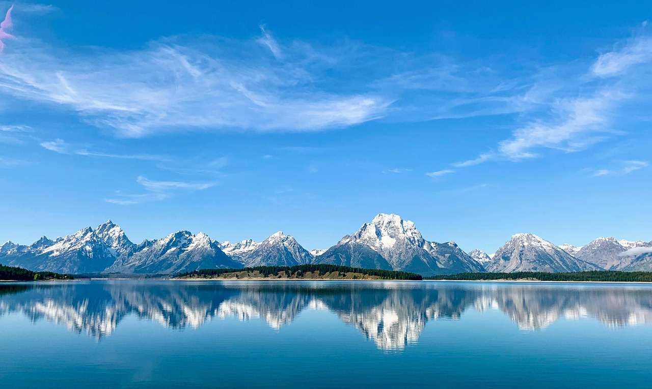 The snow-capped Teton Range reflected in a clear mountain lake