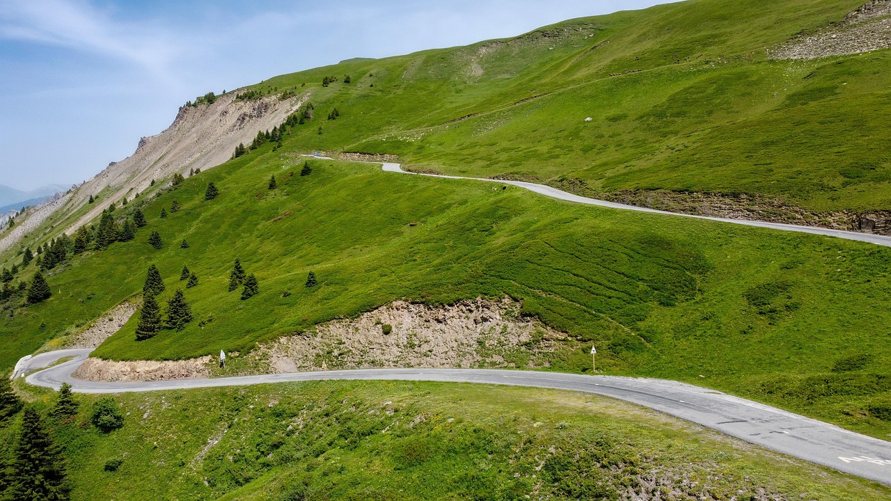 Aerial view of a winding snowy mountain pass in the Italian Alps.