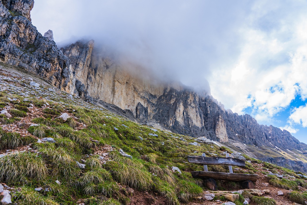 A winding path through the jagged peaks and green meadows of the Italian Dolomites.