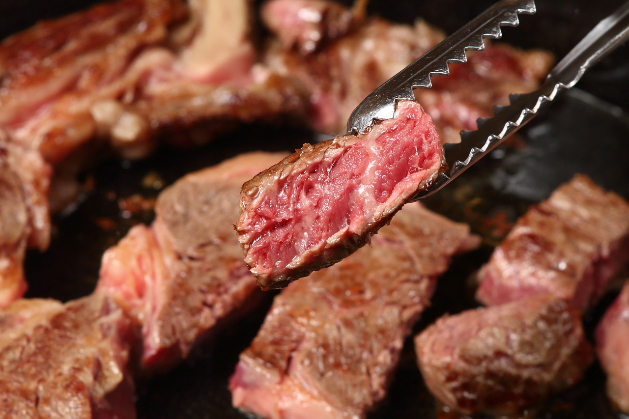 A thick, juicy steak being cooked on a traditional Argentine parrilla.
