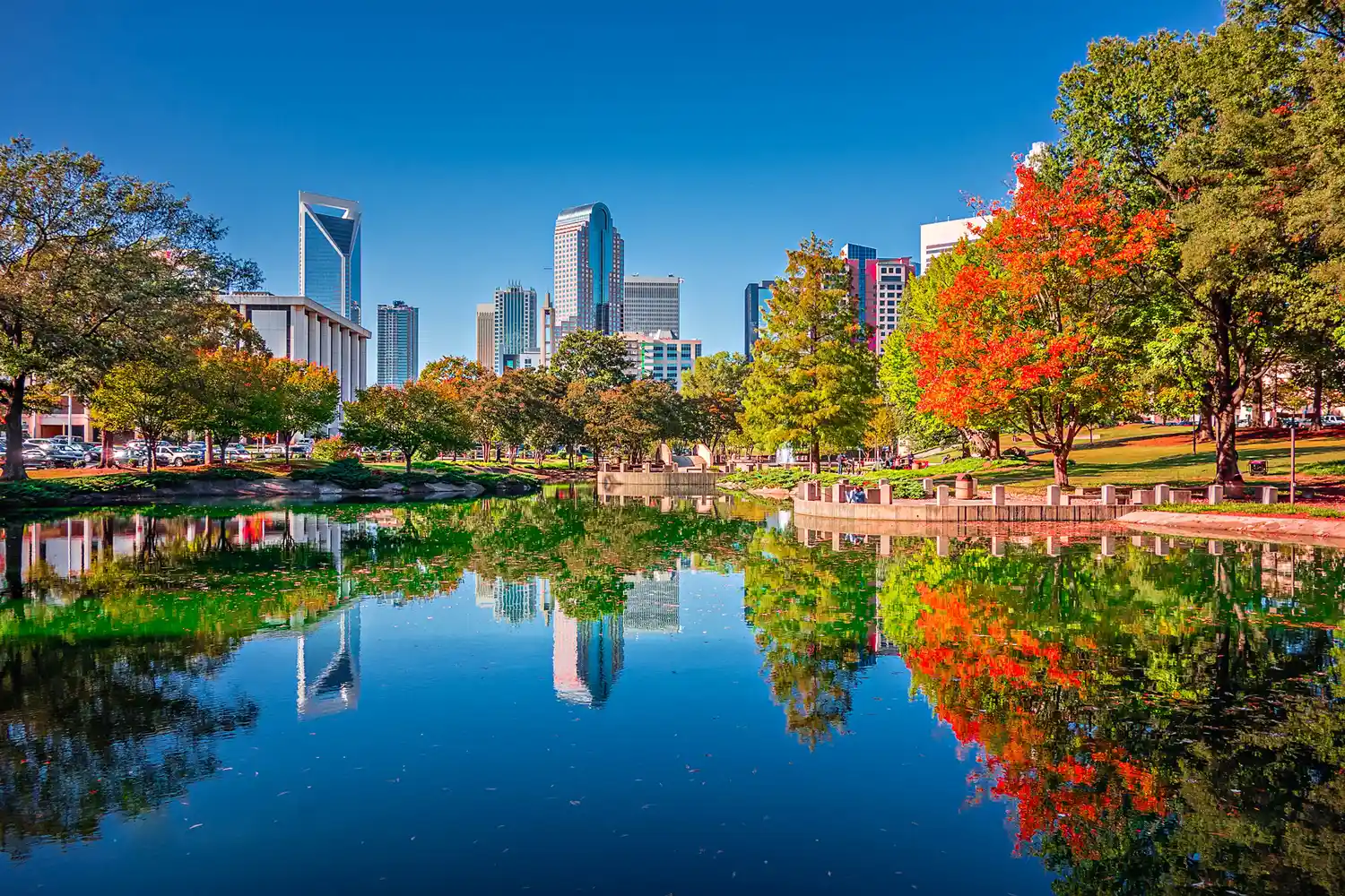 The Charlotte, North Carolina city skyline reflected in a calm lake at Marshall Park.