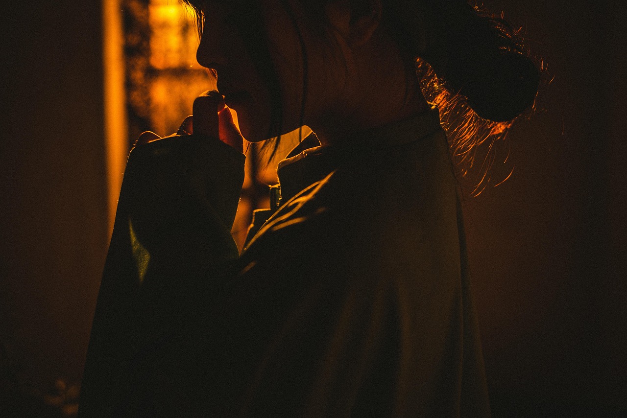 A long, dimly lit hotel corridor with vintage wallpaper and antique doors.