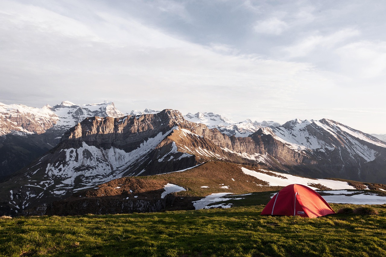 A sturdy orange four-season tent pitched in deep snow during a winter expedition.