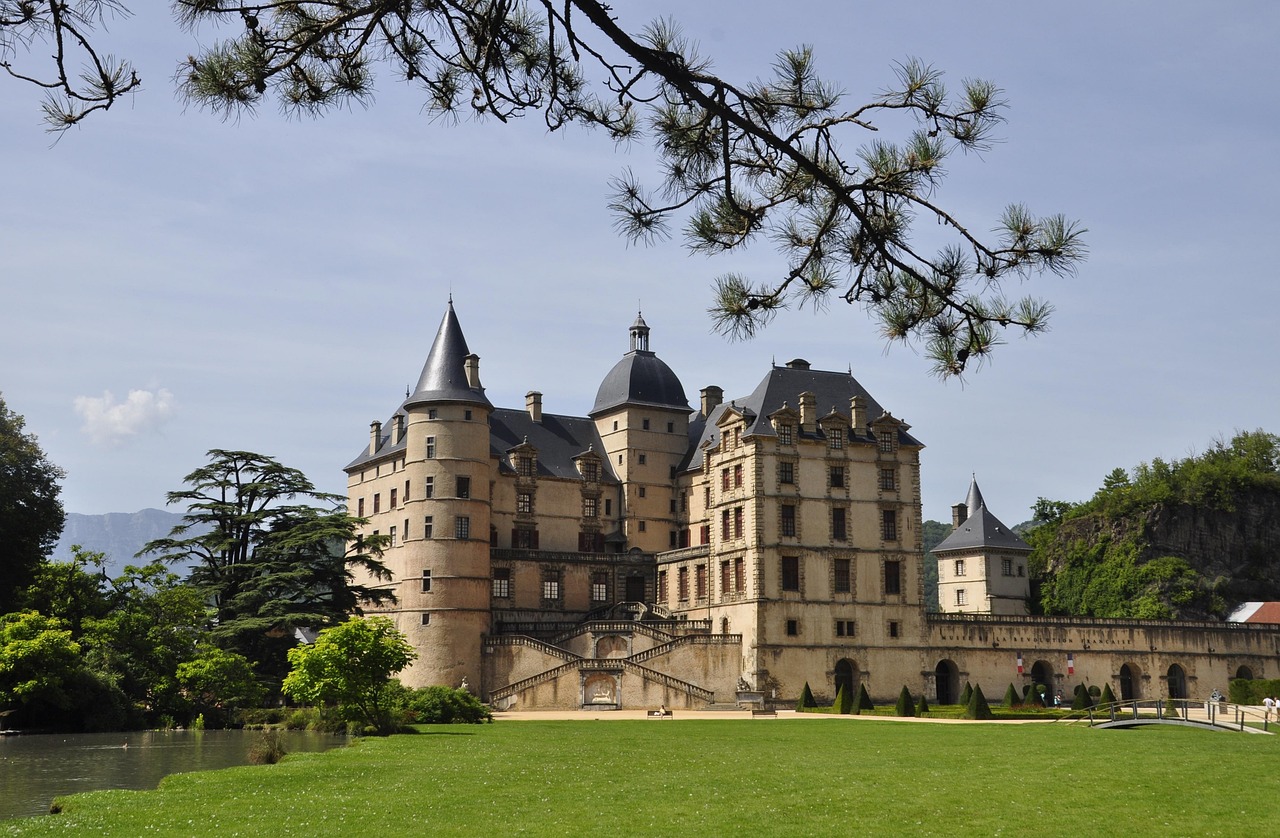 A luxurious French chateau with a large swimming pool and symmetrical manicured gardens.