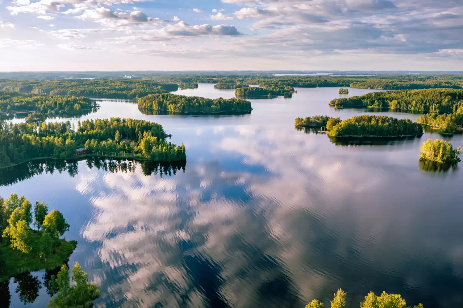 An expansive aerial view of the interconnected islands and blue waters of the Finnish Lakeland.