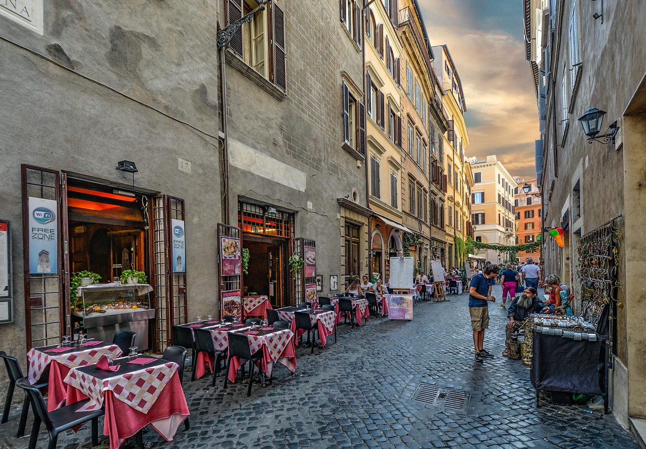 A narrow cobblestone street in Trastevere with ivy-covered walls and a small restaurant
