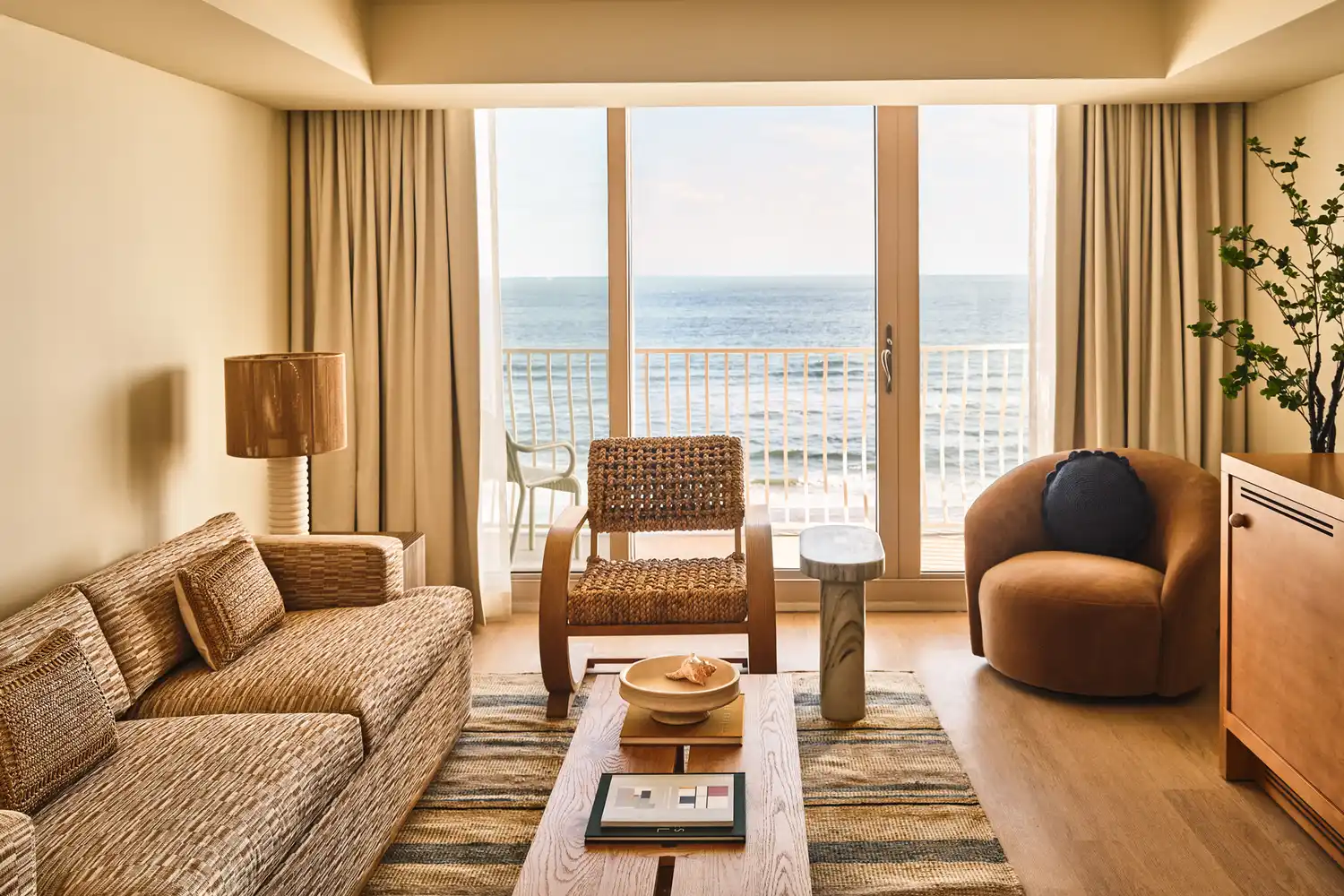 Interior of a Dune House guest suite featuring wicker furniture and an ocean view.