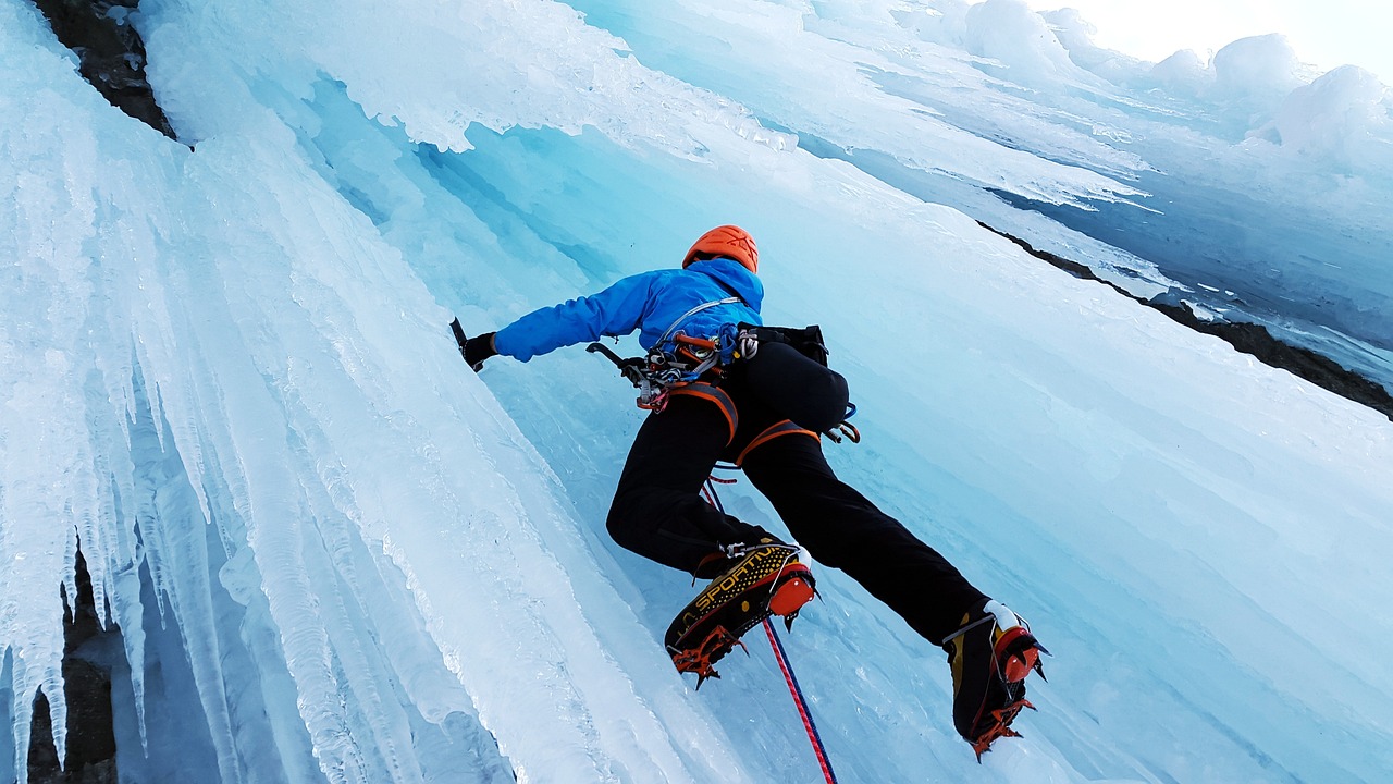 Climbers using technical gear on a steep icy glacier slope.