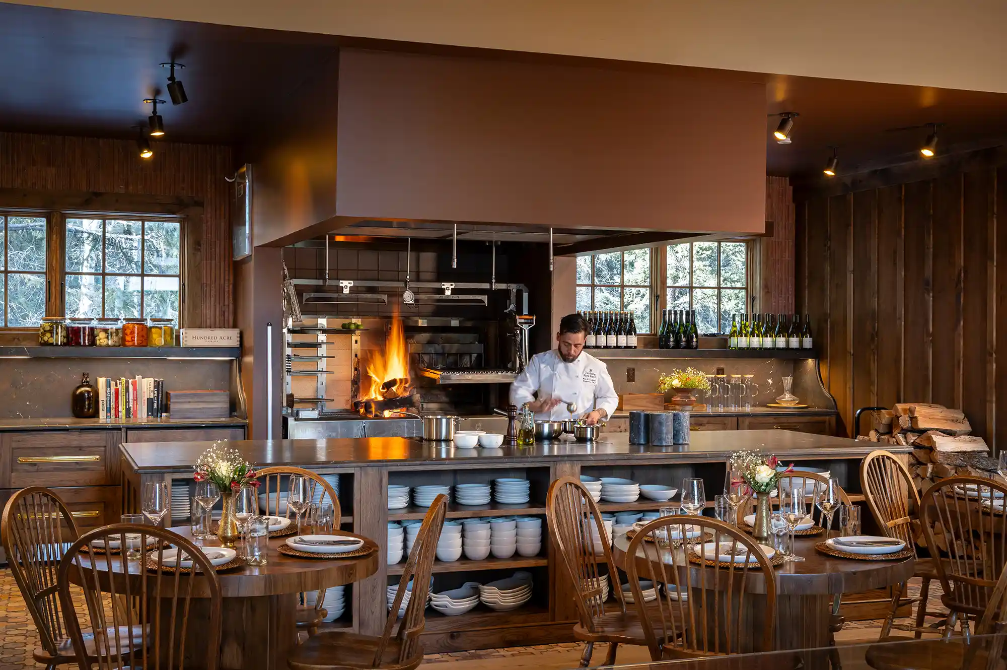 A chef preparing gourmet meals in a rustic, open-concept kitchen at a luxury Colorado ranch resort.
