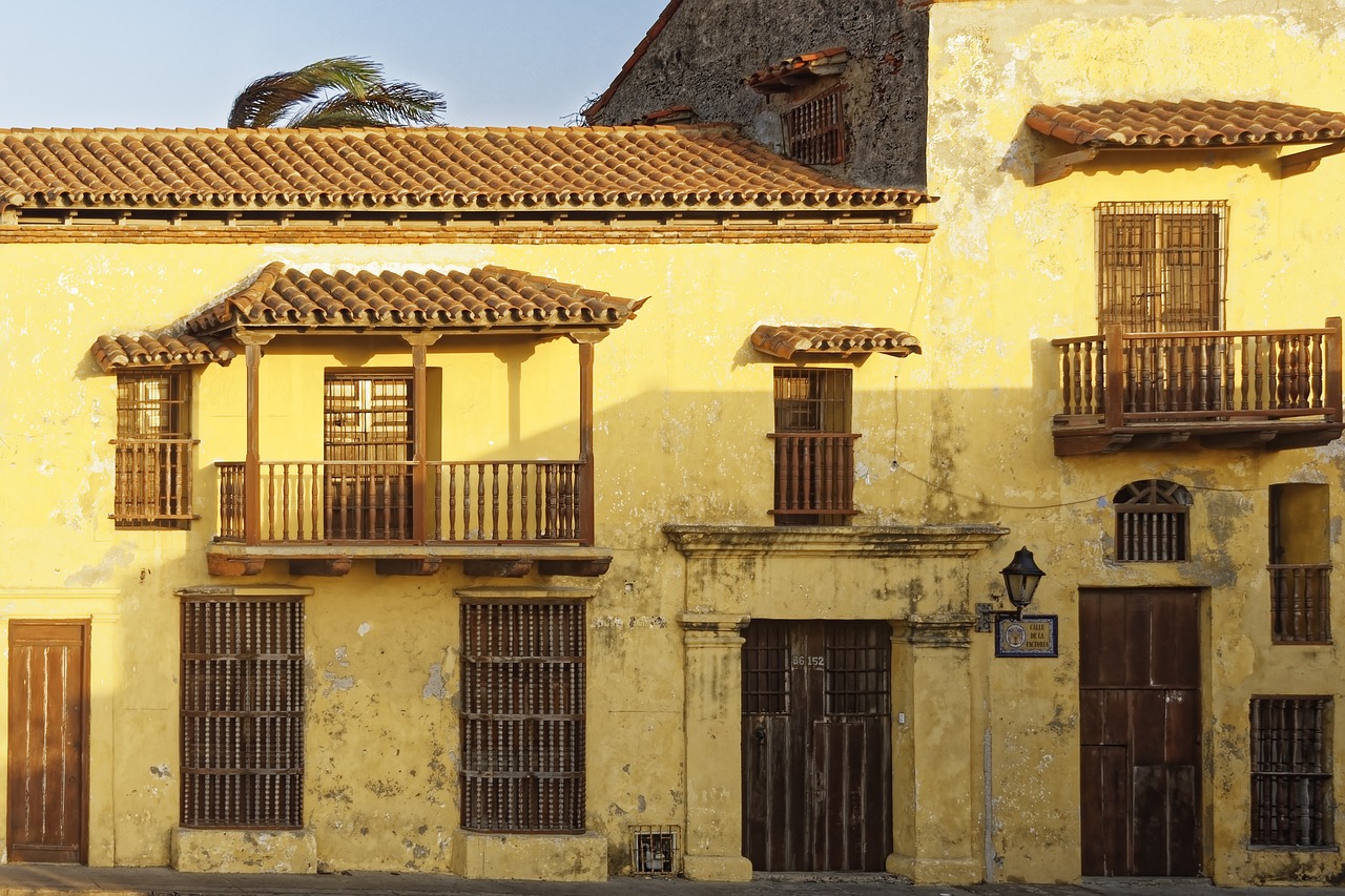 A sunny day at a historic plaza in Cartagena with palm trees.